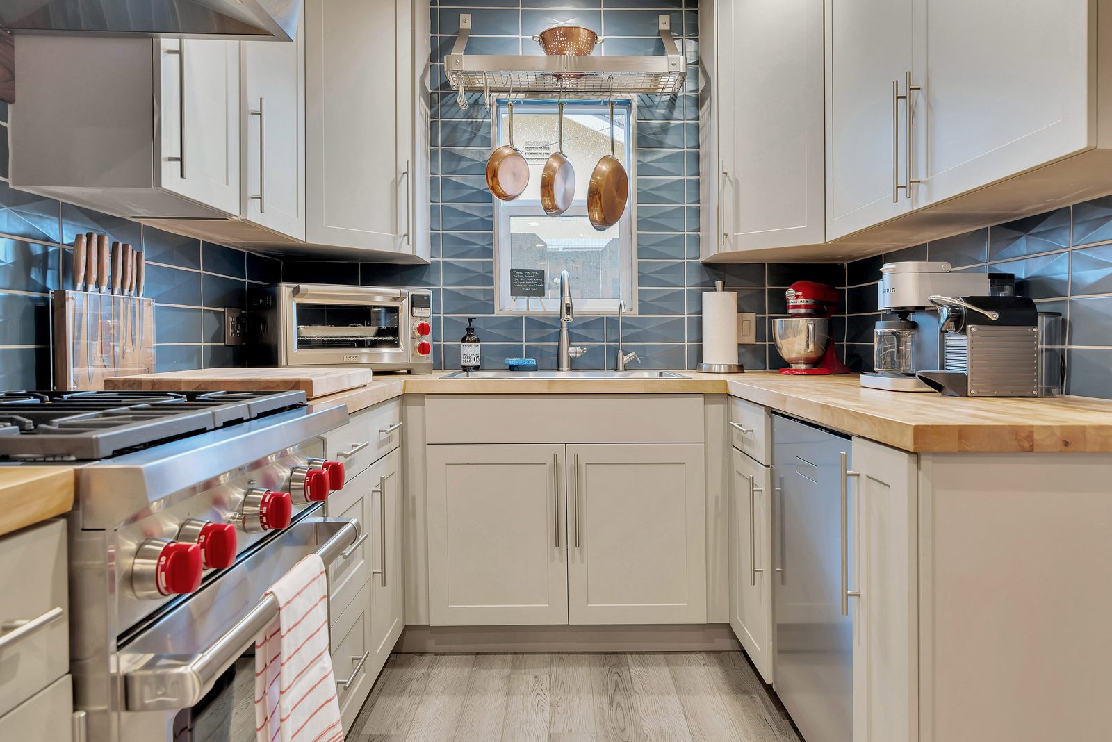 Kitchen with professional Wolf range, butcher block counters and blue tile at Marvelous Midcentury, a vacation rental on Oak Street in Paso Robles