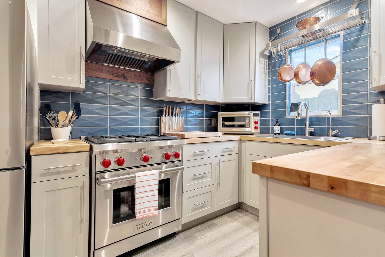 Kitchen with professional Wolf range, butcher block counters and blue tile at Marvelous Midcentury, a vacation rental on Oak Street in Paso Robles