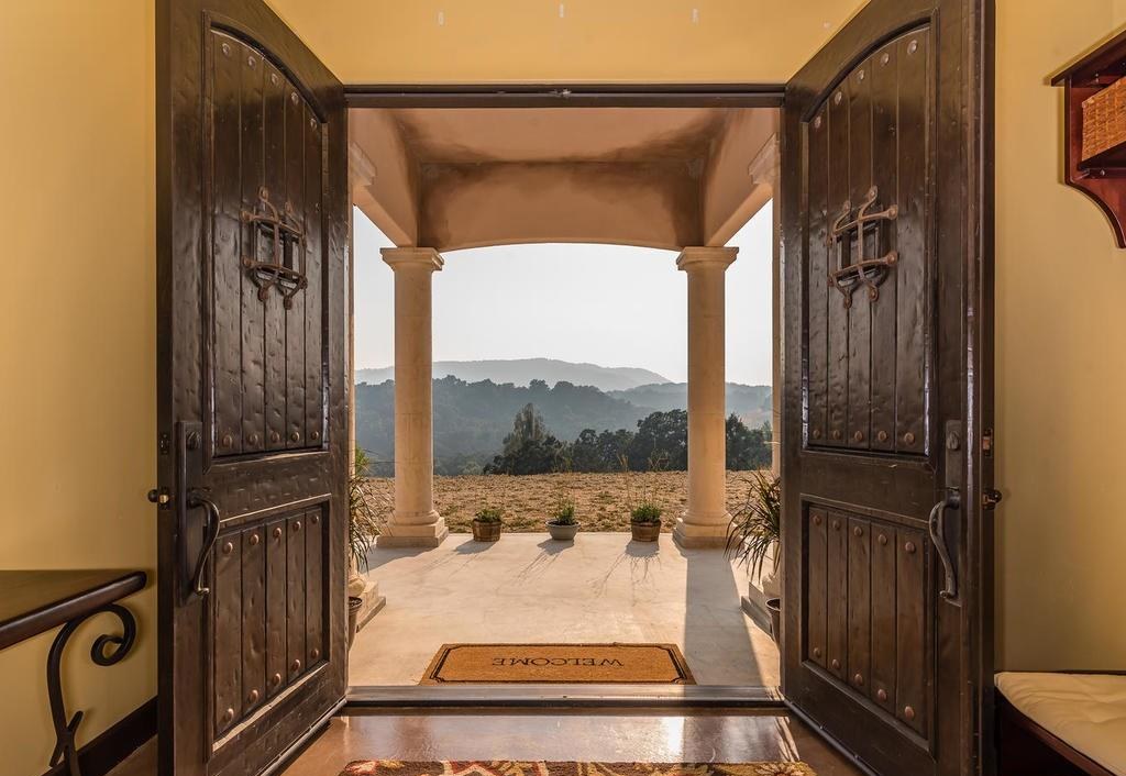 Entry doors framing hillside vineyard views at Vino on Vineyard, an estate vacation rental on the Westside Wine Trail in Paso Robles