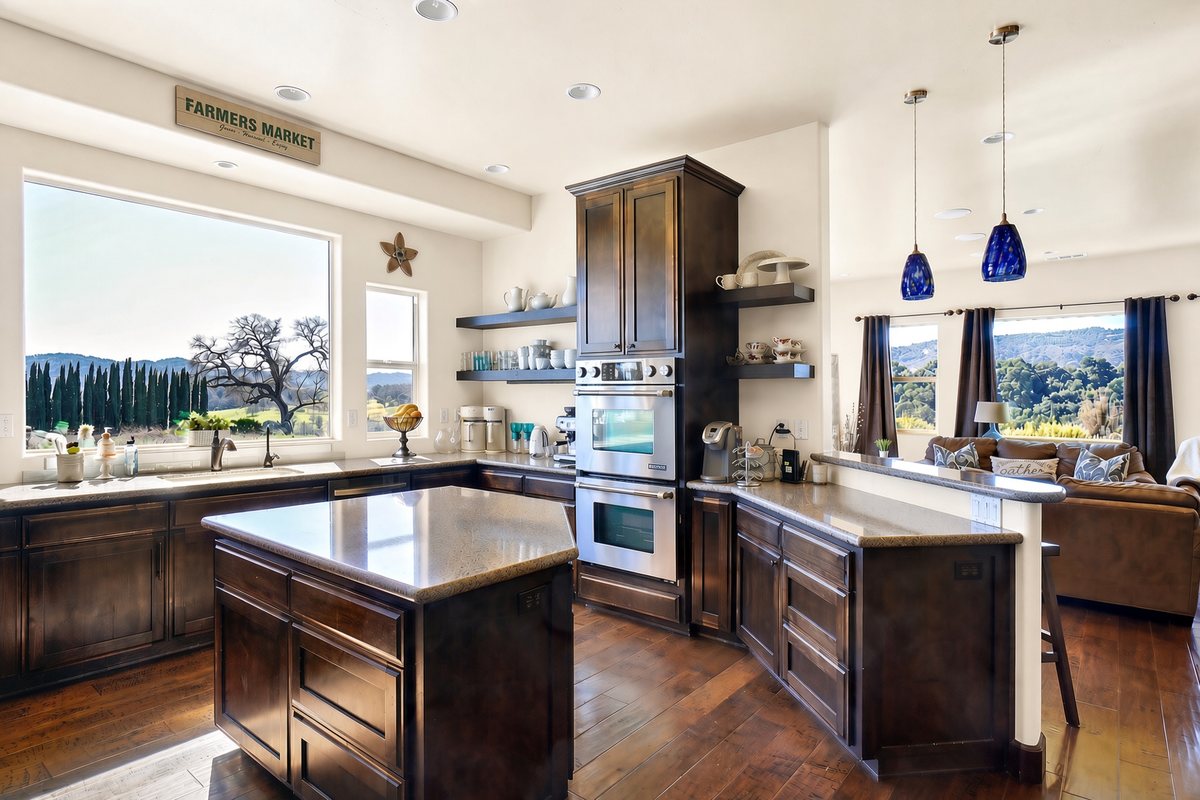 Kitchen with double ovens and oak-studded vineyard views at Vino on Vineyard, a hillside estate vacation rental on the Westside Wine Trail in Paso Robles