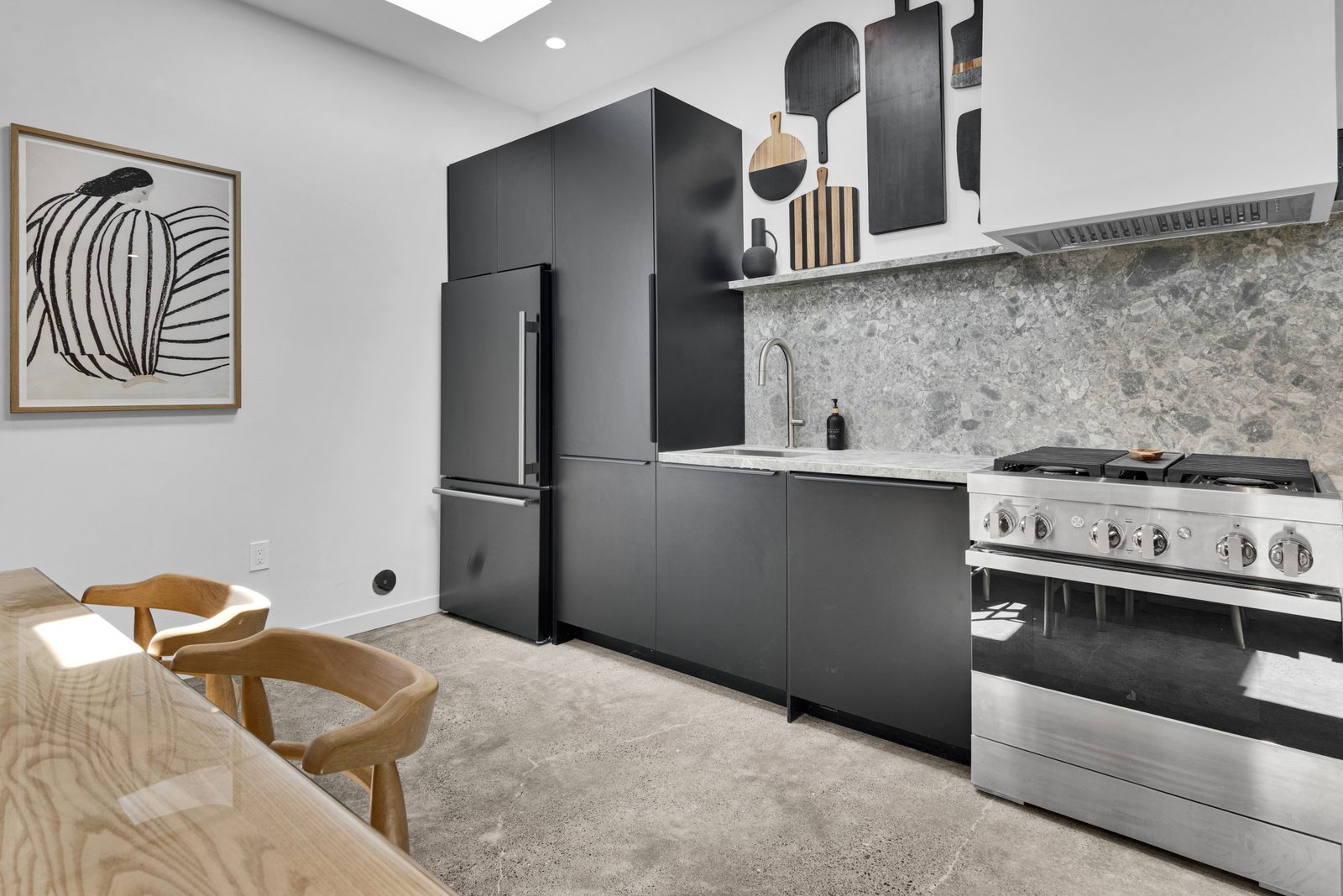 Kitchen with JennAir range, matte black cabinetry and terrazzo backsplash at Walk on the Westside, a one-bedroom vacation rental in Paso Robles